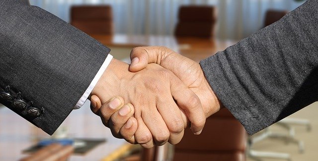 Two gentlemen shake hands when a brokerage firm has been chosen.